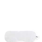 Beyaz pamuklu uyku maskesi, yan tarafında marka etiketi.